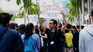 Male student holding up protest sign