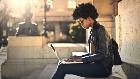 Student on her computer sitting on steps