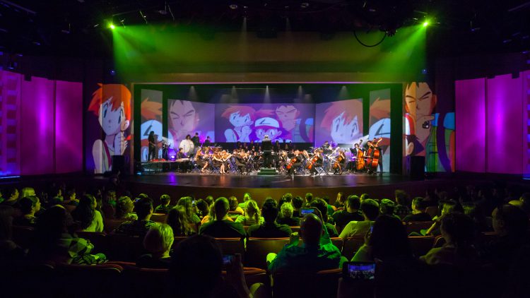Ochestra onstage with video projections and audience