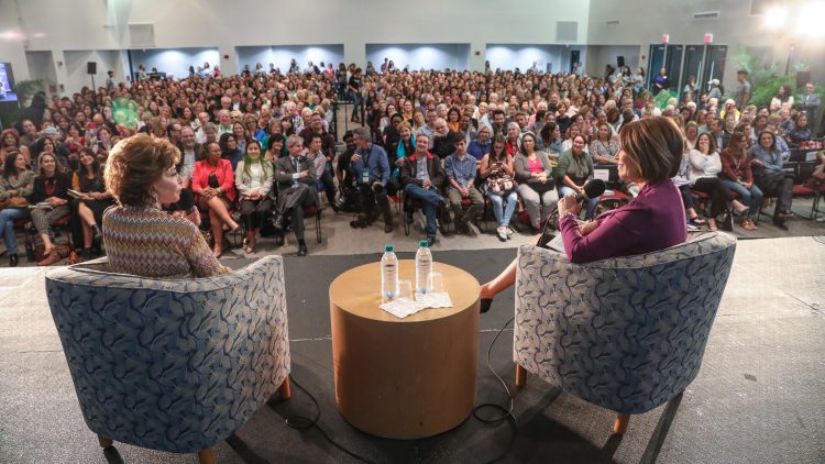 Author and Interviewer sit on stage with audience looking on