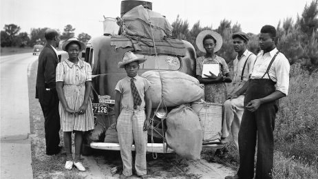 Group of Black migrants standing around their car