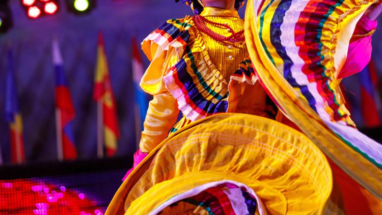 Siwlring Mexican dress with Latin American flags in background
