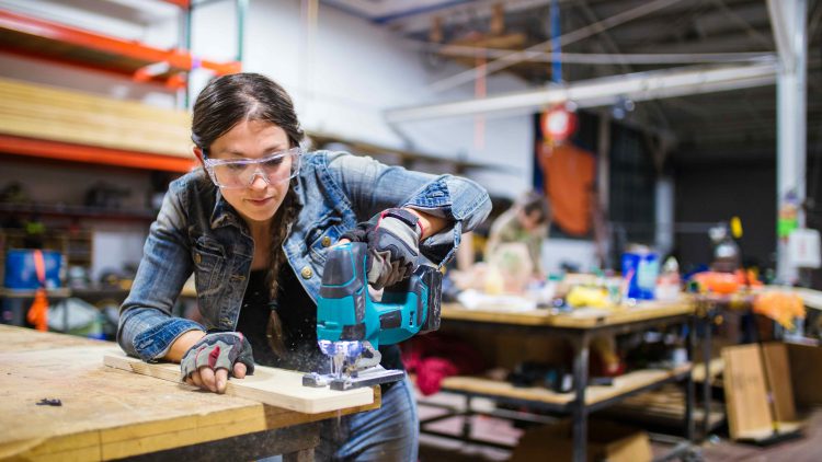 Young woman using a power tool
