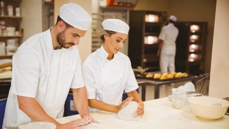 two chefs rolling out dough