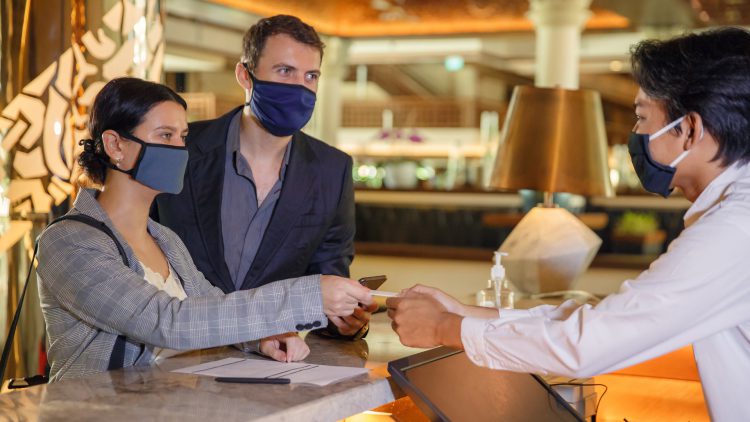 Hotel guests checking in with masks on
