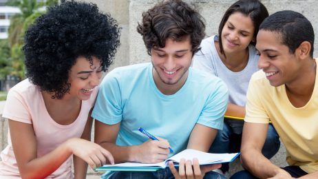 Students gathered together looking at a notebook