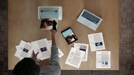 overhead shot of man with laptop and publication pages