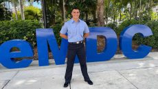 Portrait of Mikael Alfonso standing in front of MDC sign