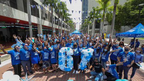 College president, staff, and students in a group holing up the number 61