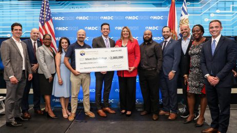 College president and others holding the grant check