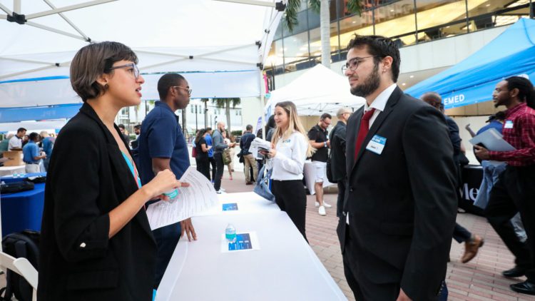 Recruiter speaking with candidate at job fair