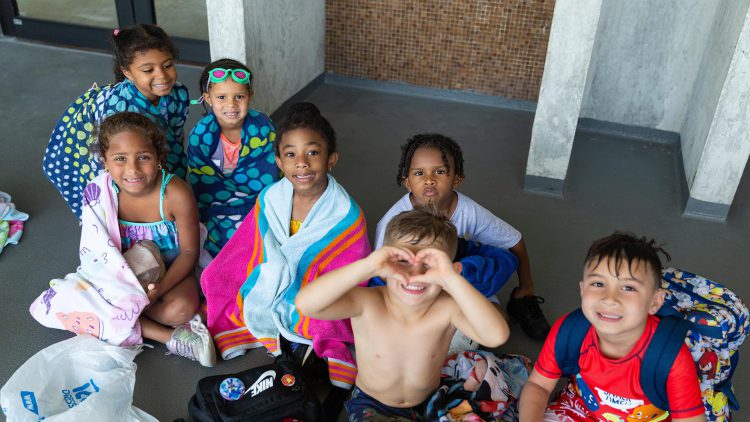 Kids wrapped in towels by the pool