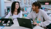 two students sitting with computers