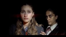 Two student actors against a black background