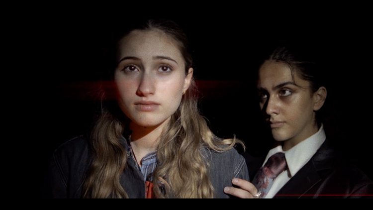 Two student actors against a black background