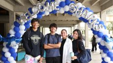 students standing under a balloon arch that reads: Welcome Sharks