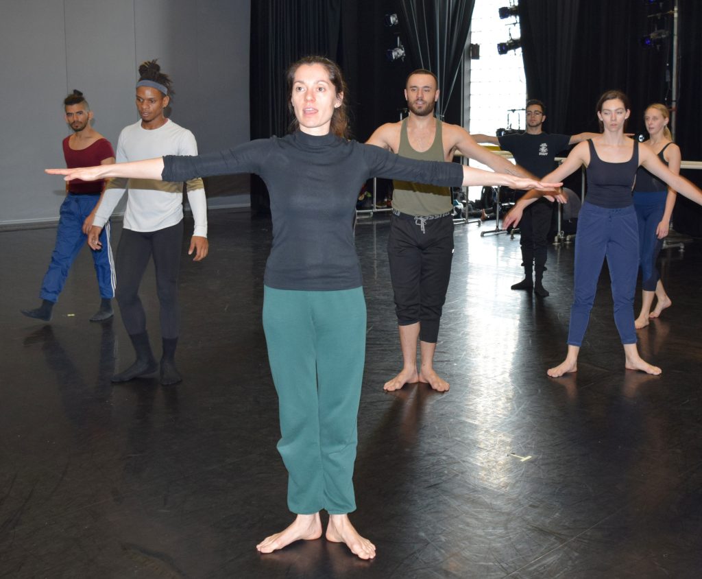 Dance instructor leading a class of dancers in the dance studio.
