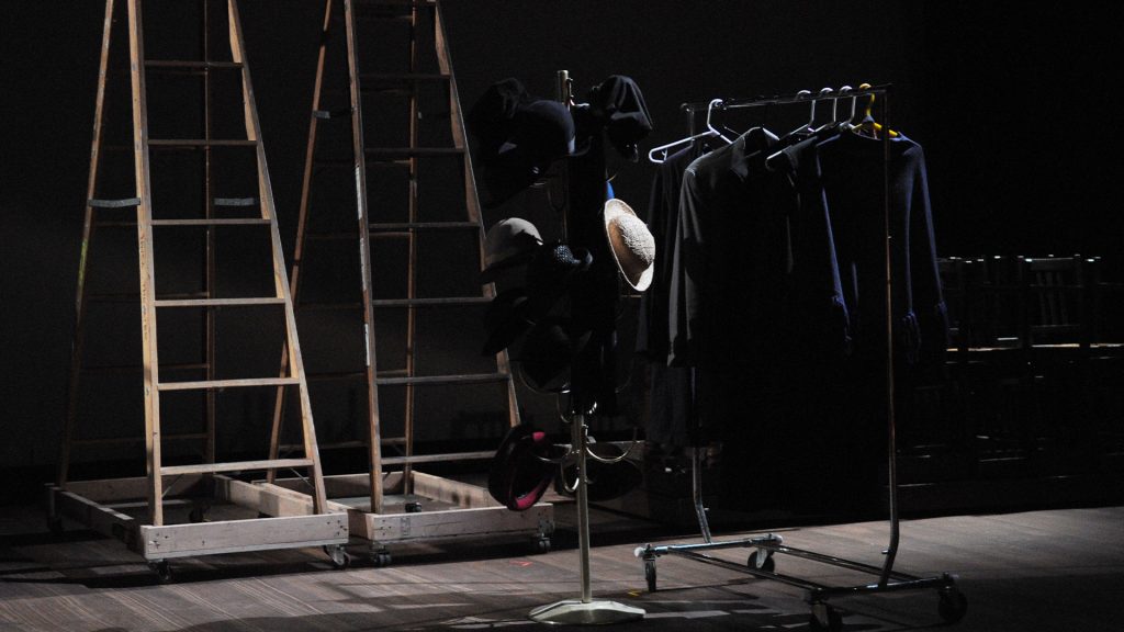 Stage se with two ladders hats and and clothing rack.
