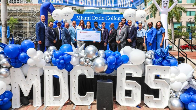 The college president with others standing on a stage outdoors celebrating I AM MDC Day