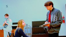 Three student actors rehearsing in a classroom.